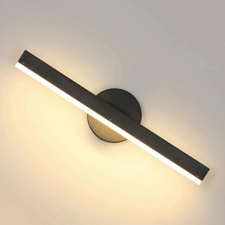 Applique murale LED orientable à 360°, disponible en noir ou blanc, Luminaire Essenza, fixé sur un mur moderne.