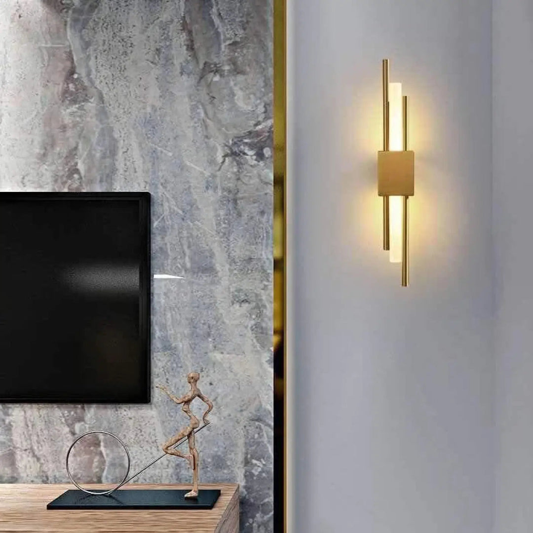 Applique murale design LED en laiton pour salon, style moderne et élégant, installation verticale.