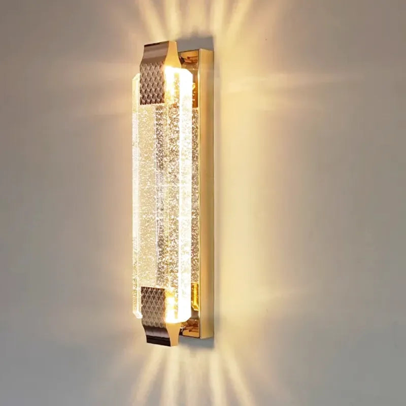 Applique murale LED de luxe Luminaire Essenza en cristal doré, moderne et élégante, avec éclairage blanc chaud et design haut de gamme.