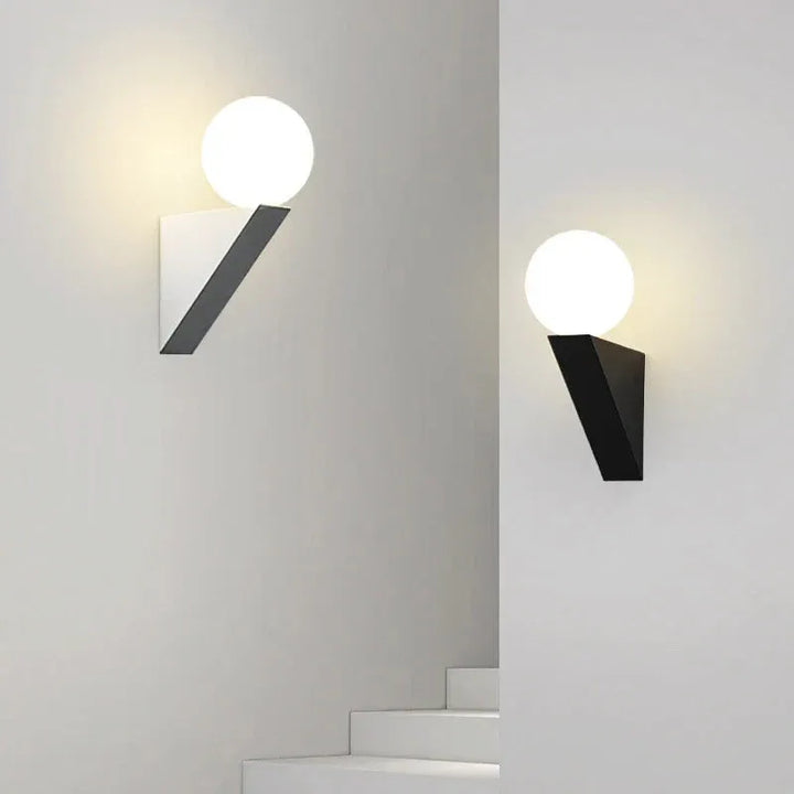 Applique murale LED moderne et luxueuse Luminaire Essenza avec boule de verre noire et blanche, éclairage chaud élégant.